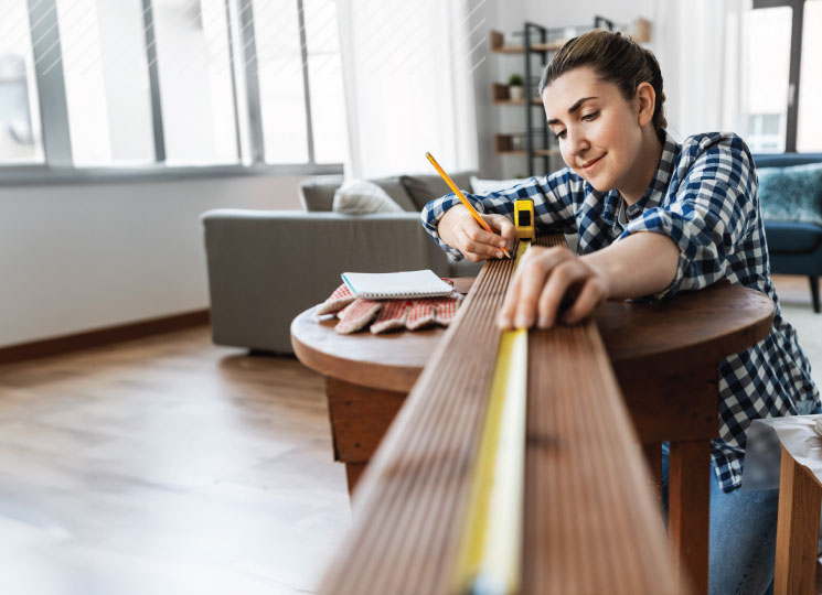 Woman measuring wood for a home equity loan renovation project