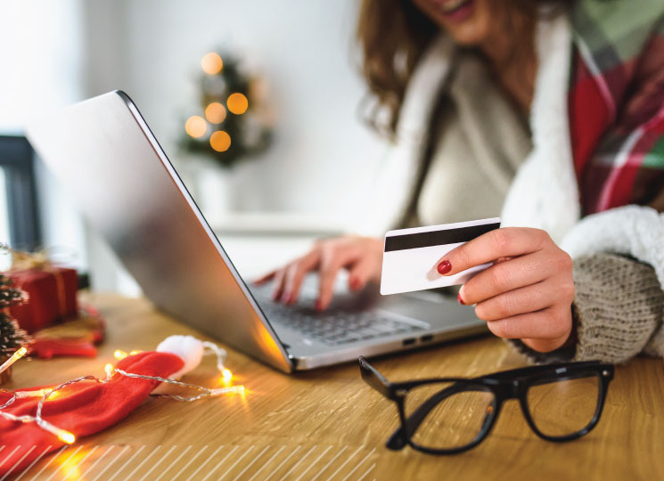 Woman making online holiday purchases with her FSB credit card.