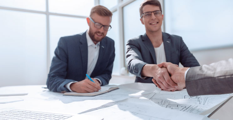 Business owner shaking hands with lender after business loan approval meeting