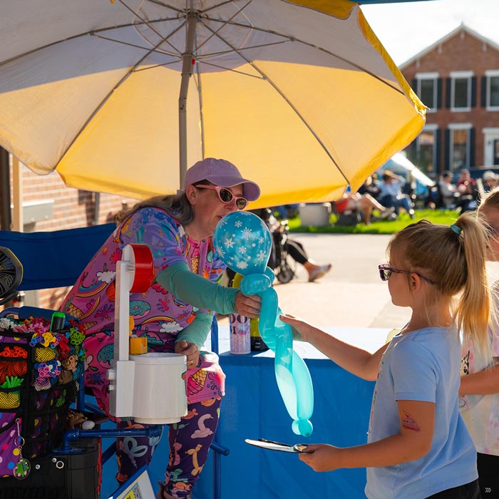 A child receives a balloon animal during Marion by Moonlight in downtown Marion
