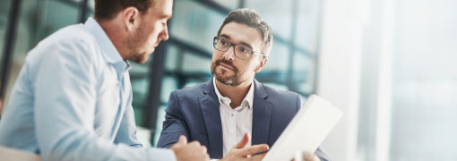 Advisor explaining investment basics during a one-on-one meeting at the Investments 101 seminar.