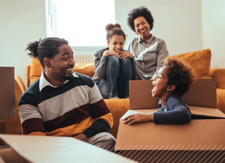 Family unpacking in new home, promoting home loans in Eastern Iowa for local buyers.