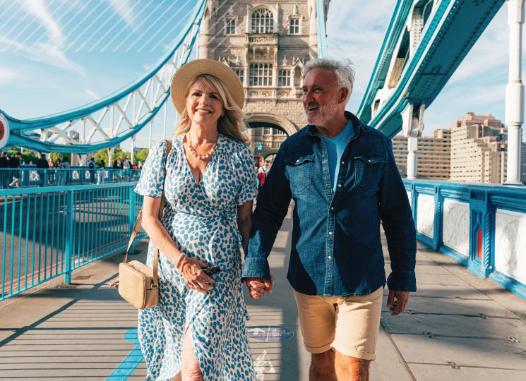 Smiling couple walking hand in hand on a sunny travel adventure.