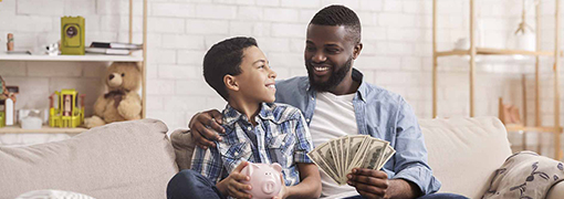 Dad teaching his son financial literacy and the importance of saving.